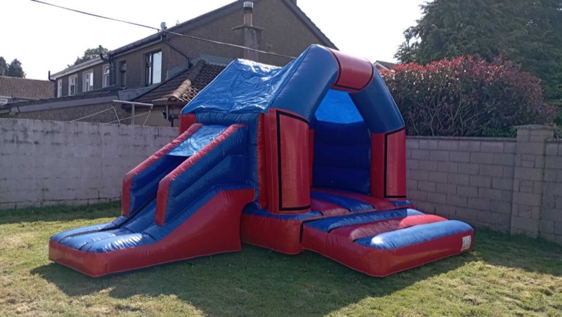 Classic blue and red bouncy castle with slide for parties in Cork