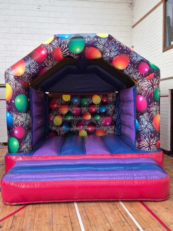 Purple bouncy castle with balloon and firework design for parties in Cork
